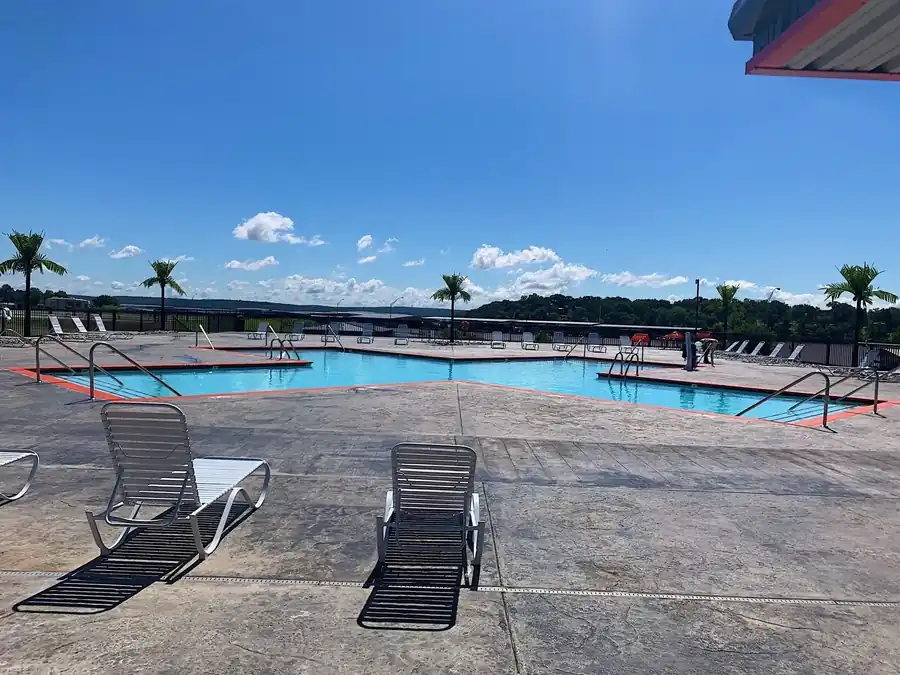 A large multi basin resort pool with orange trim and stamped concrete decking under an Oklahoma sky