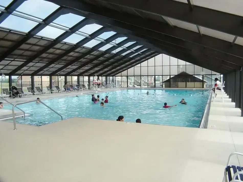 An indoor pool natatorium with a glazed gable roof, built for year-round commercial use